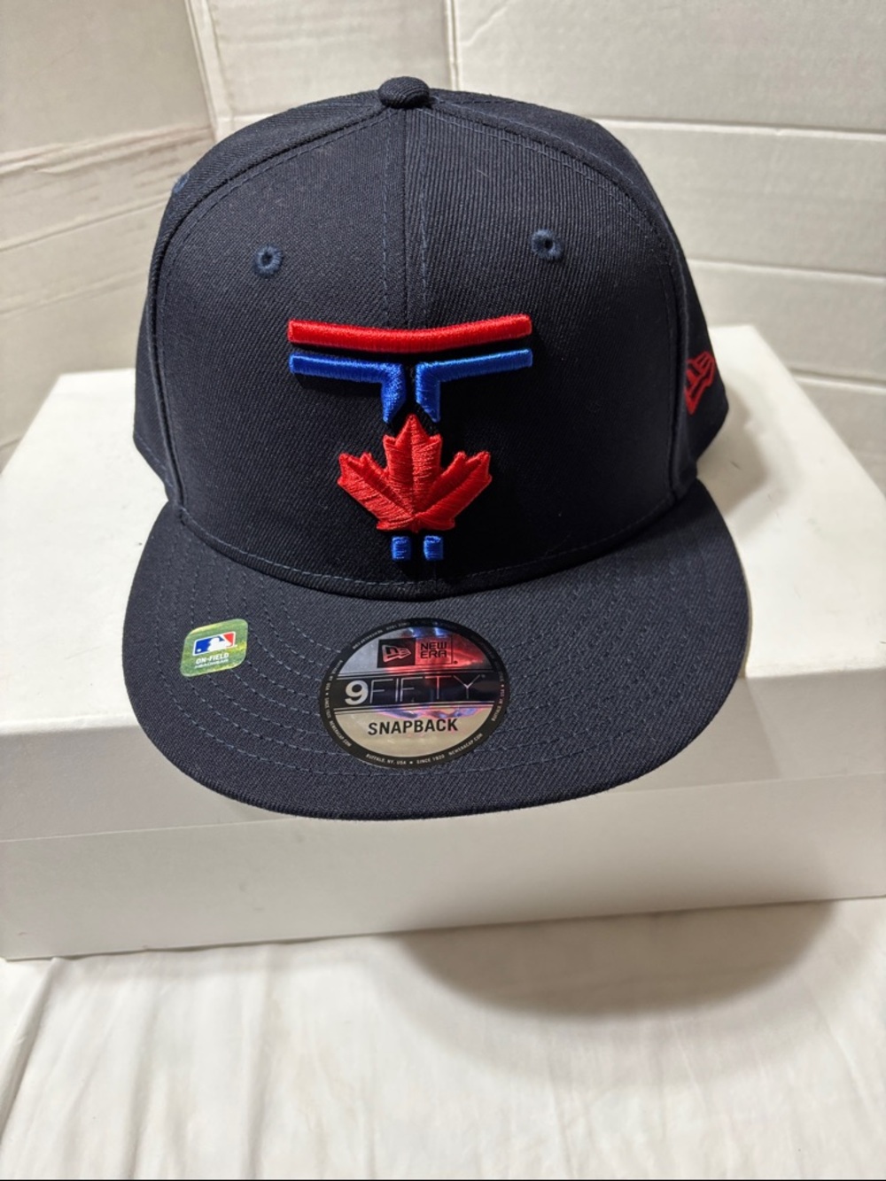 Toronto Blue Jays New Era Navy Snapback Hat with Red and Blue Maple Leaf Logo